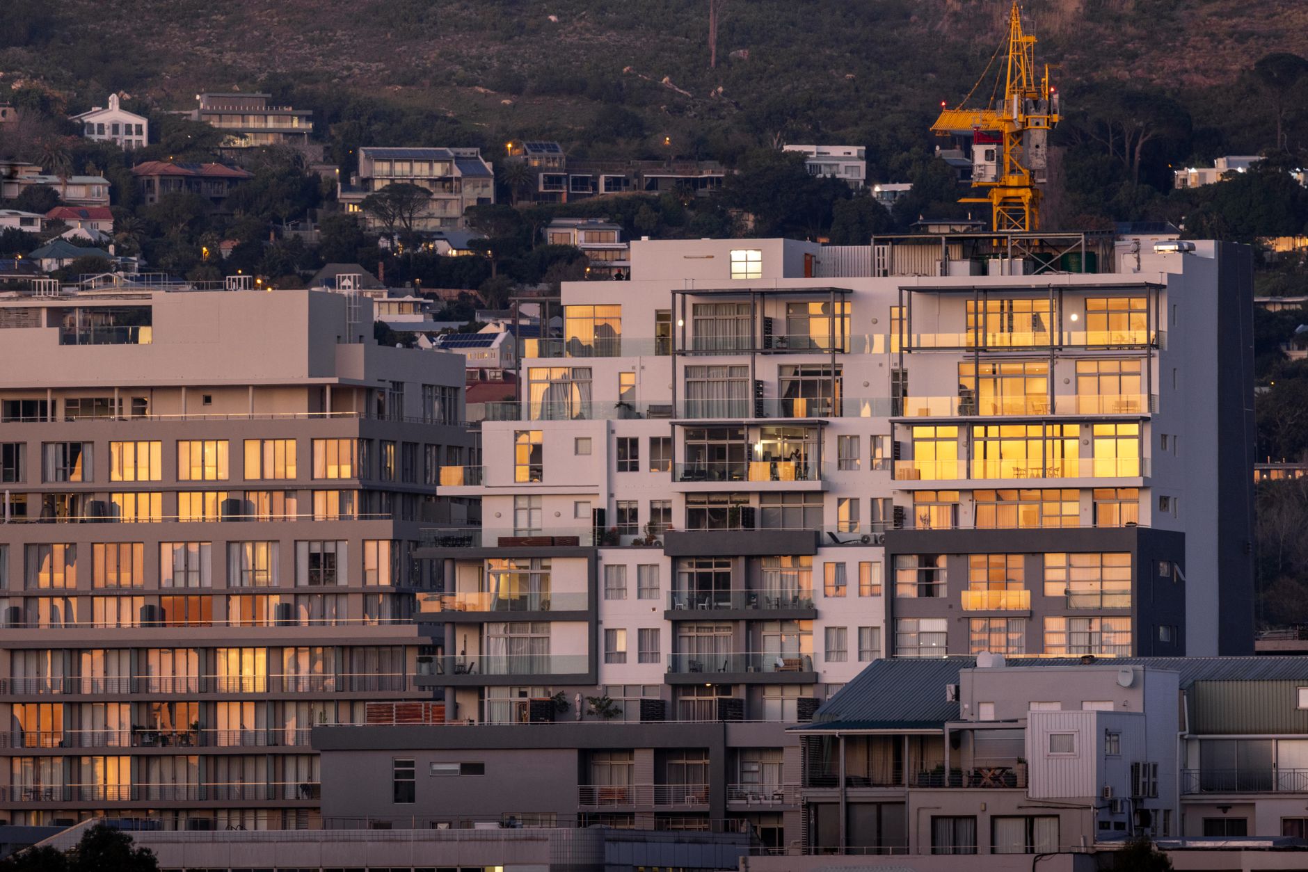 Construction cranes operate above a large multifamily housing development as U.S. residential building activity rebounds.