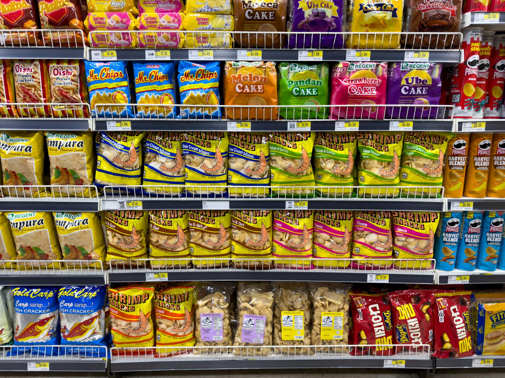 A shopper walks through a supermarket aisle stocked with household and personal care products as consumer goods companies report earnings.