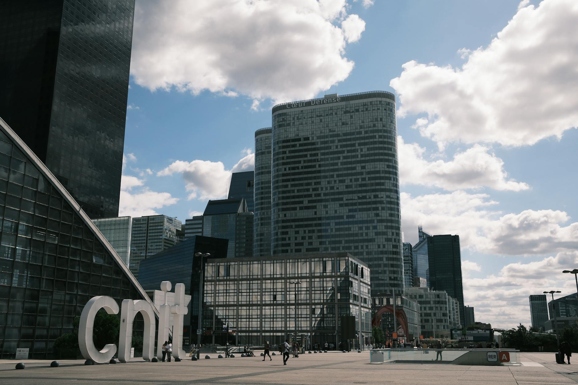 People walk through a Paris business district as new PMI data point to a sharper contraction in French private-sector activity.