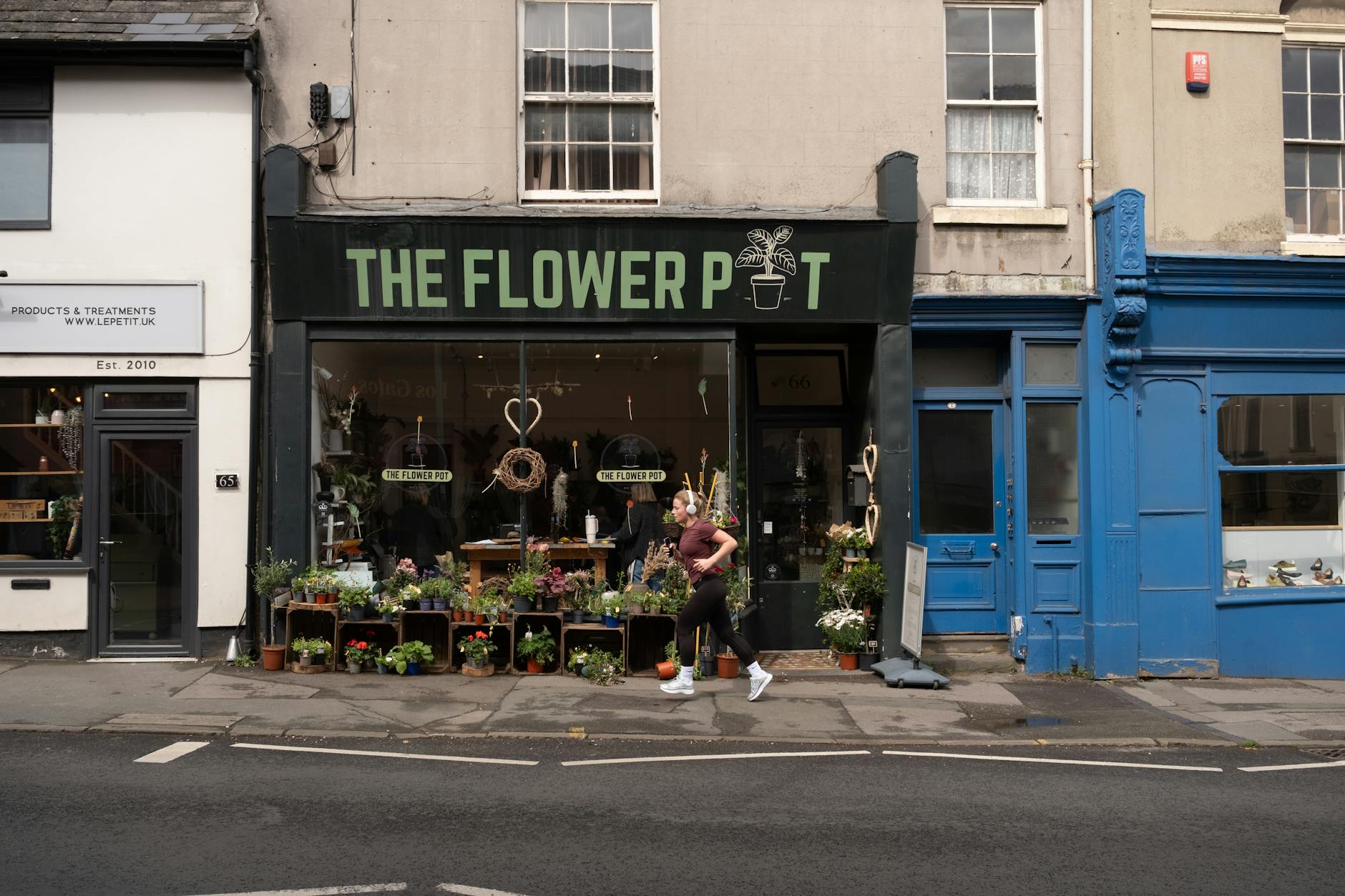 Shoppers pass retail storefronts in Britain as weaker fuel purchases and cautious consumer demand weigh on April sales.
