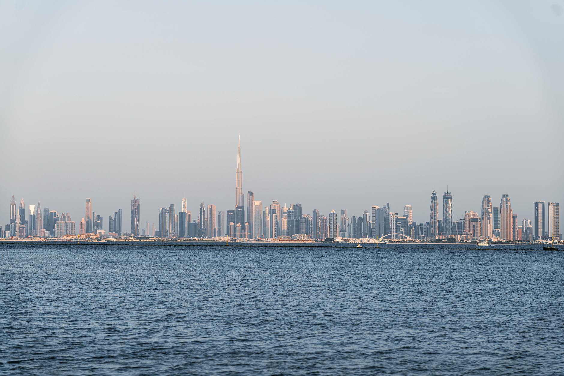 The UAE skyline at sunset with business leaders discussing economic growth amid a backdrop of rising GDP figures.