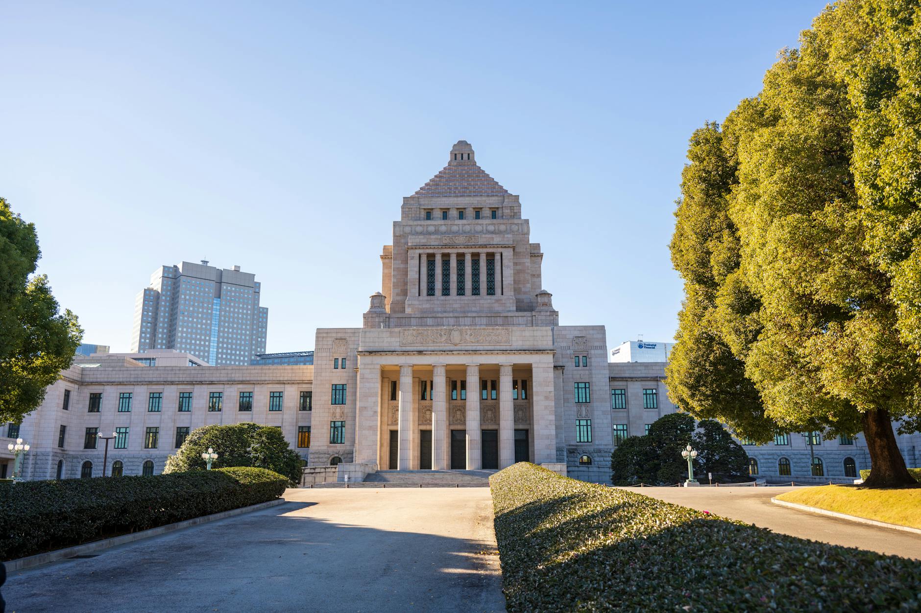 Bank of Japan headquarters with financial market displays showing yen exchange rate movements