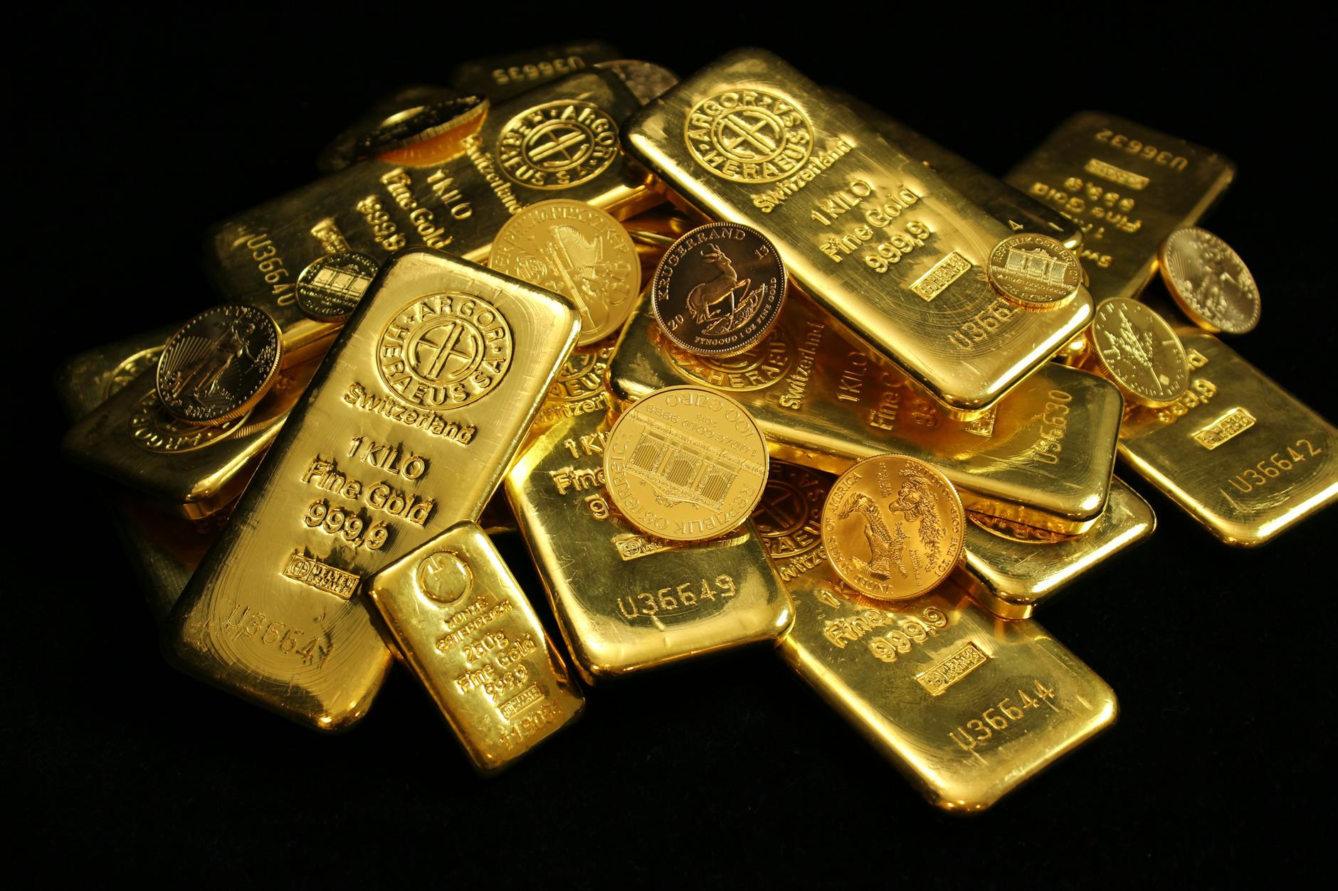 Gold bars and ETF market data screens illustrate shifting global demand for gold-backed exchange-traded funds.