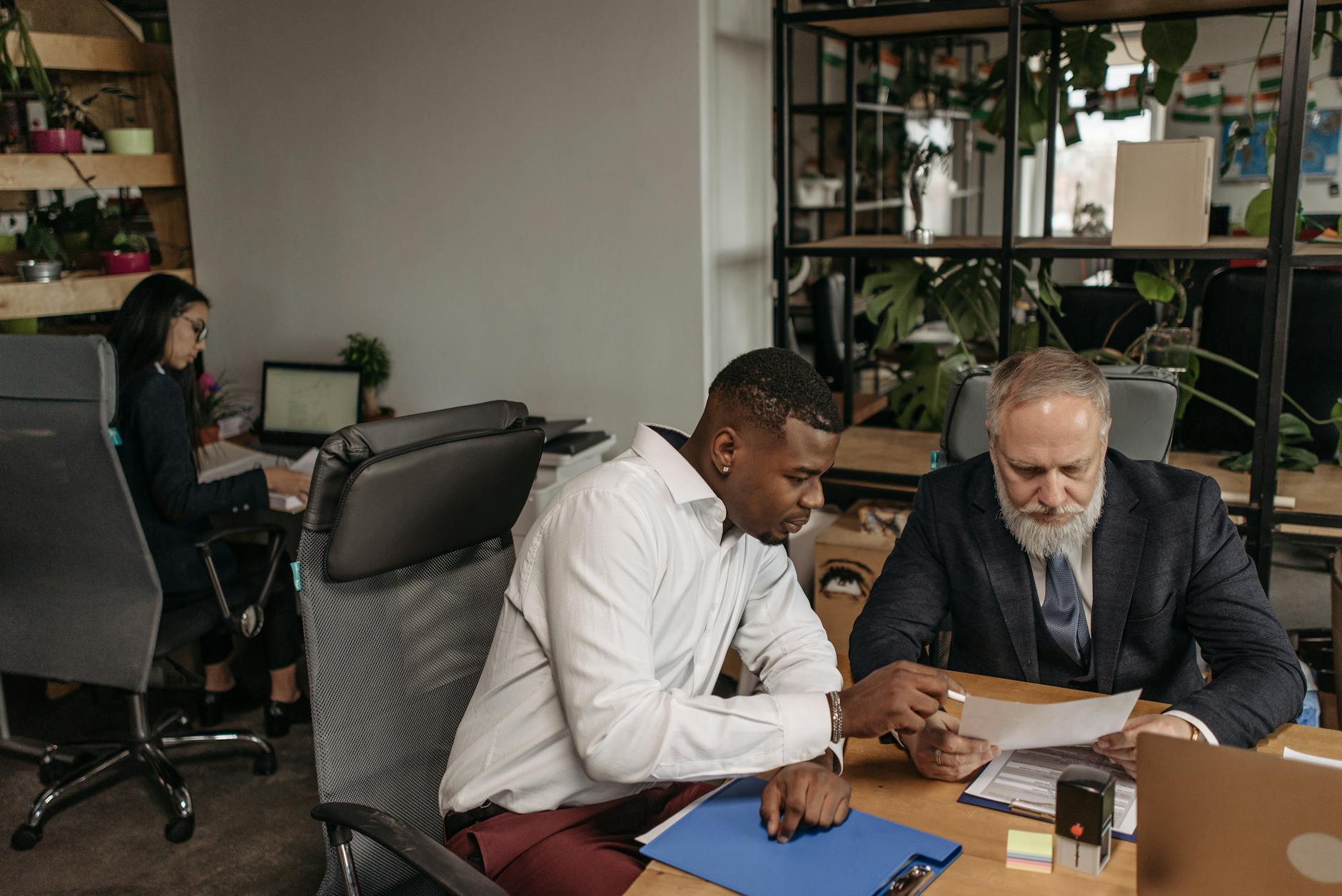 Financial advisors meet with clients in a wealth management office as Raymond James expands its advisor network.