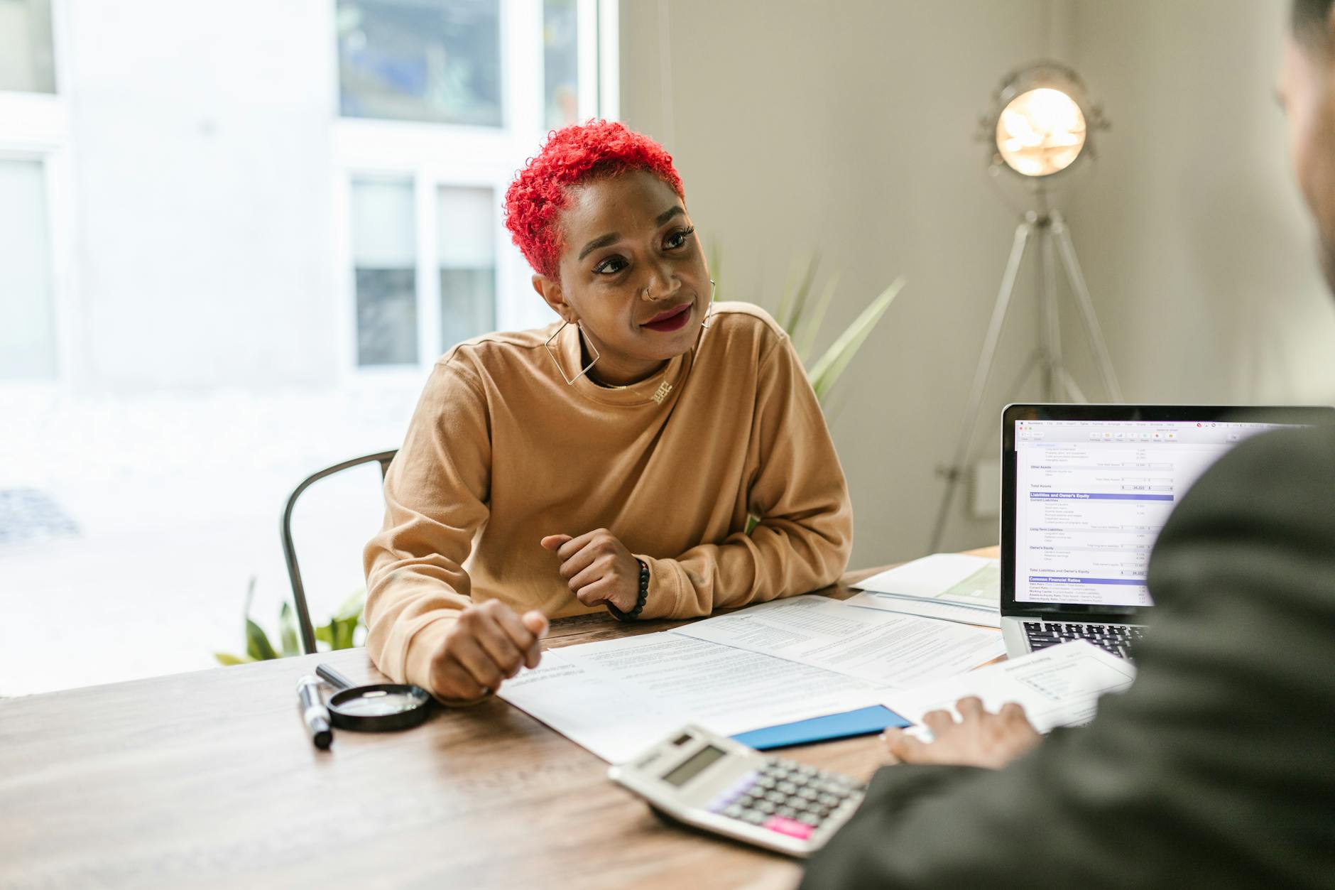 A financial advisor discusses aging-care and longevity planning materials with clients in an office setting.