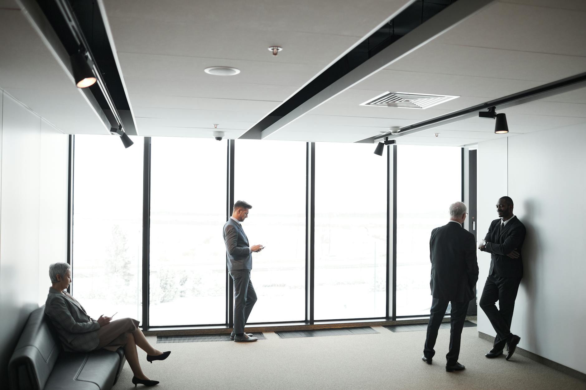 Financial advisors meet with clients in a modern wealth management office to review investment and planning documents.