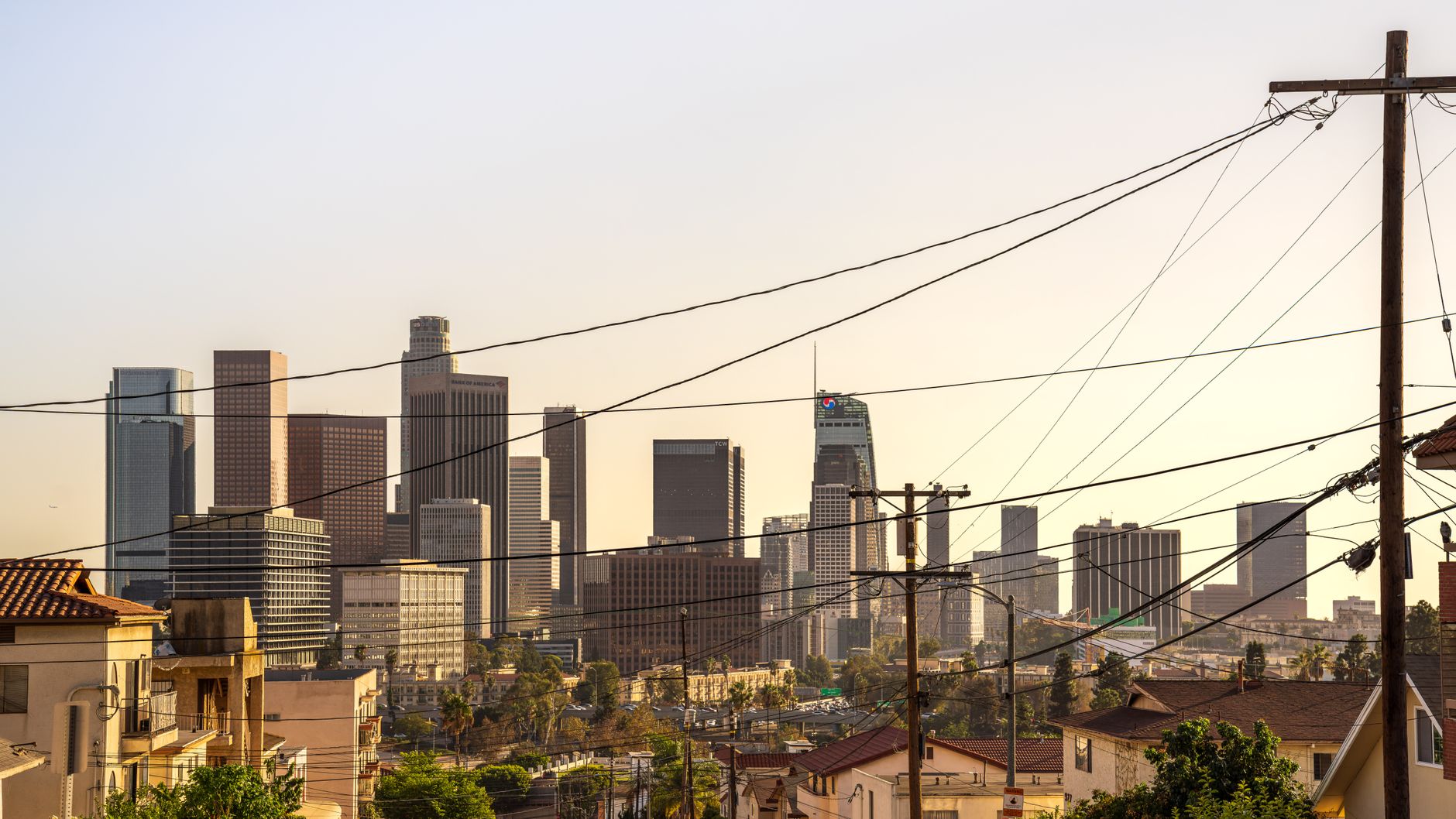 Private equity executives discuss a potential acquisition against the backdrop of the Los Angeles financial district.