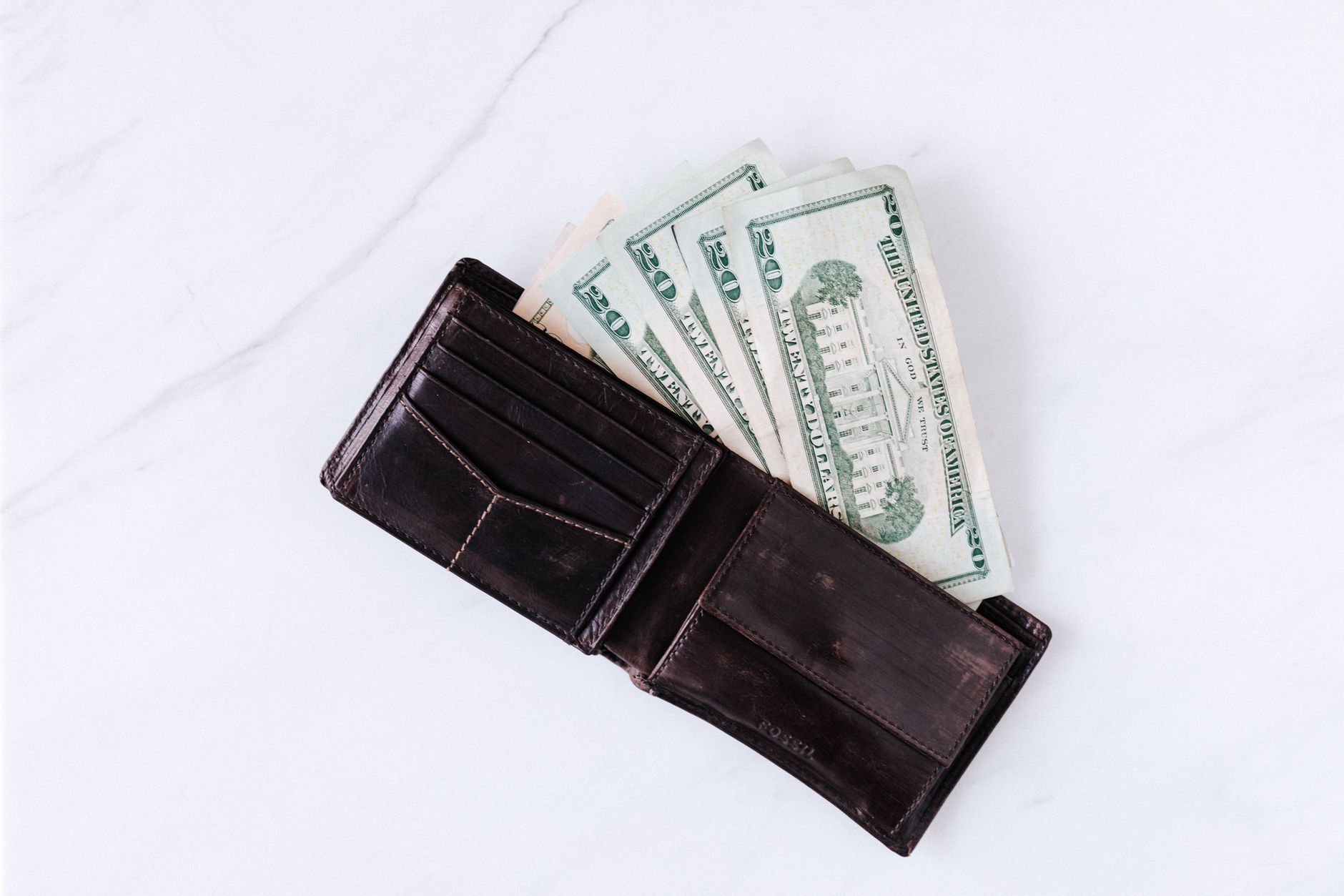 A smartphone displaying the X platform beside a payment card illustrates the U.S. rollout of X Money accounts and wallet services.