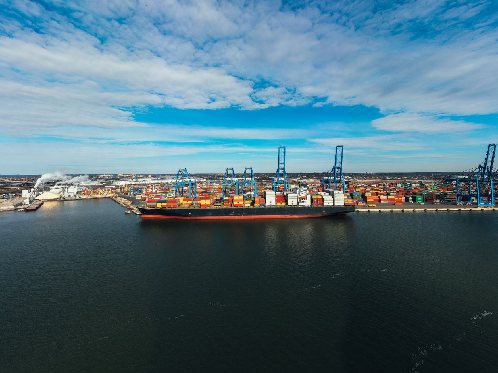 Shipping containers at a U.S. port illustrate rising import prices and broader pressure on internationally traded goods.